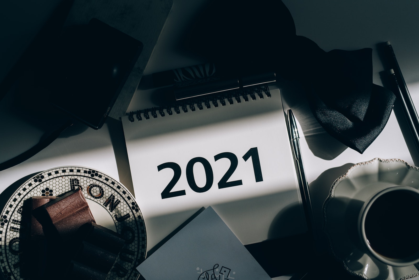 A 2021 Desk Calendar Beside a Saucer and a Pen